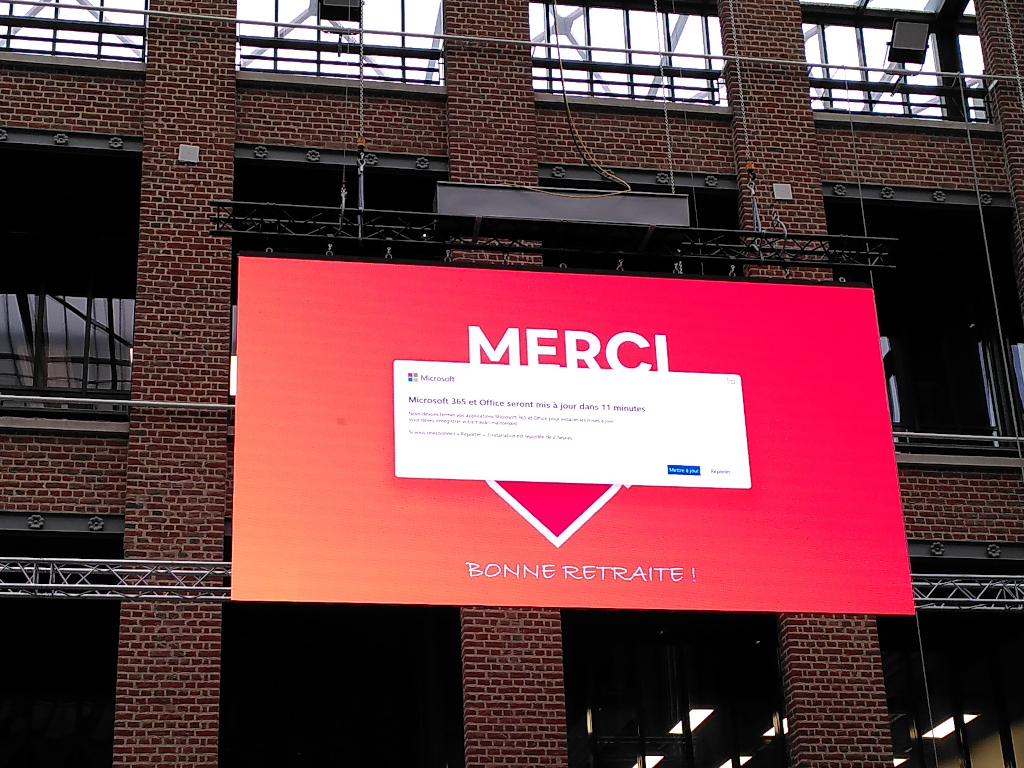 Photographie de l’écran géant d’Euratechnologies avec une fenêtre de mise à jour en surimpression de la communication sensée être affichée.